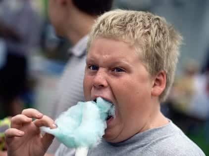 Boy (12-14) eating cotton candy, close up