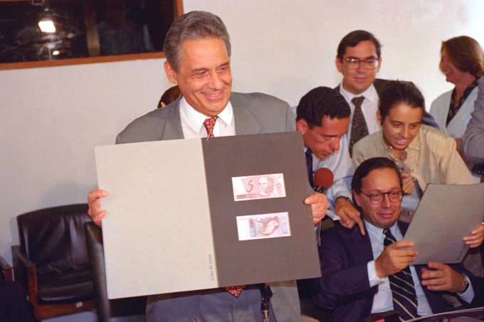 Fernando Henrique Cardoso, ministro da Fazenda, exibe cédula da nova moeda, o real, em 30 de março de 1994